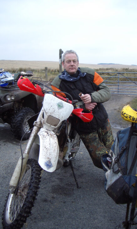 Picture of Colin Horn, Managing Director and founder of Grosvenor Interiors leaning on a crosser motorbike

